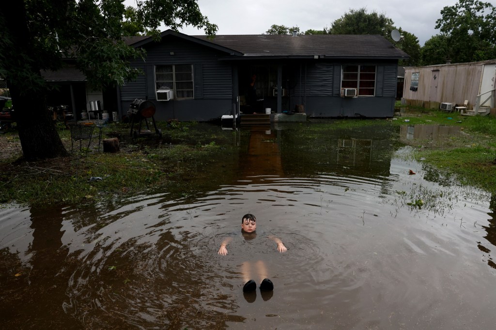 A boy floats in the flood waters caused by Hurricane Beryl on Monday.