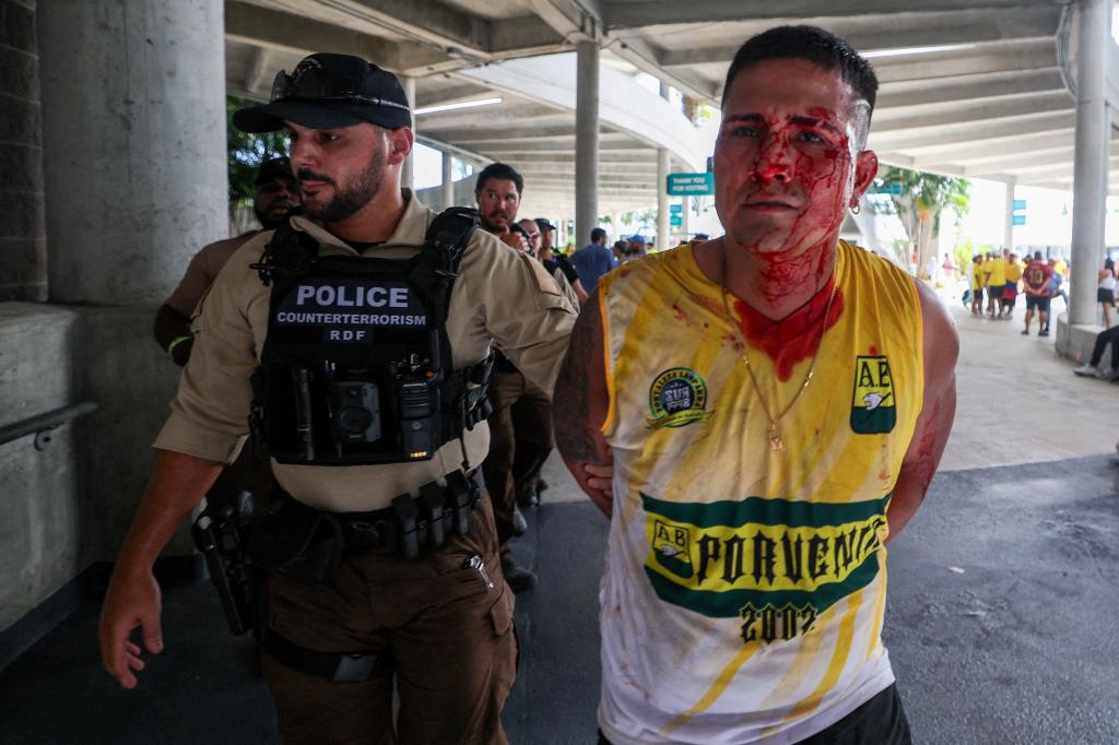 A fan is detained by police before the Copa America Final match between Argentina and Colombia at Hard Rock Stadium.