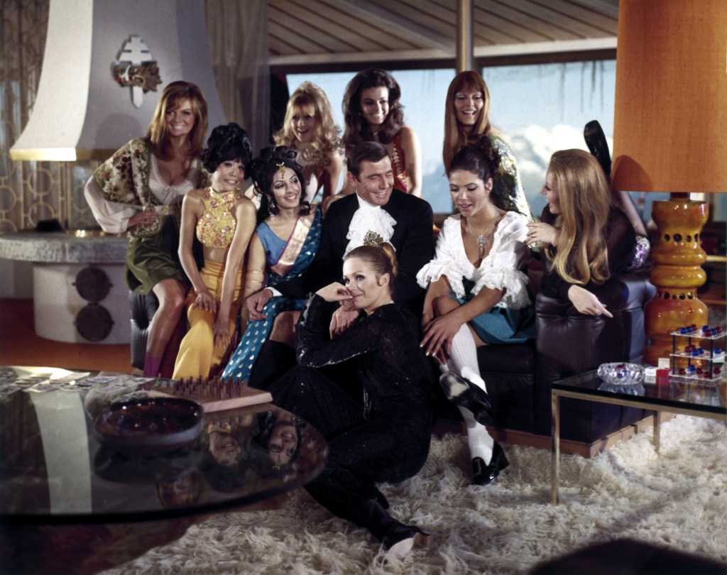 George Lazenby surrounded by women on the set of "On Her Majesty's Secret Service."