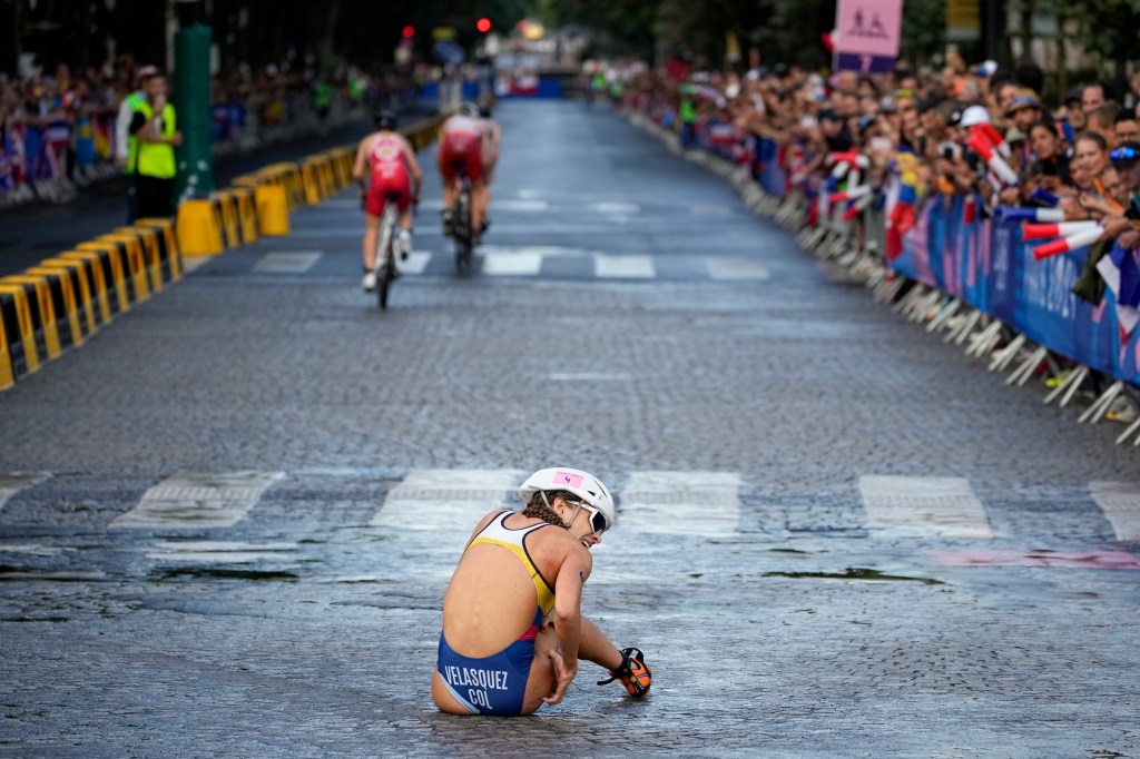 Columbia's Maria Carolina Velasquez Soto sits on the pavement after crashing during the bike leg of the women's triathlon on July 31, 2024.