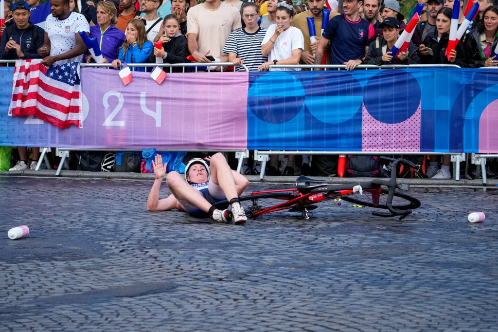 A handful of athletes crashed off their bicycles after slipping on the wet cobblestones of the Champs-Elysees.