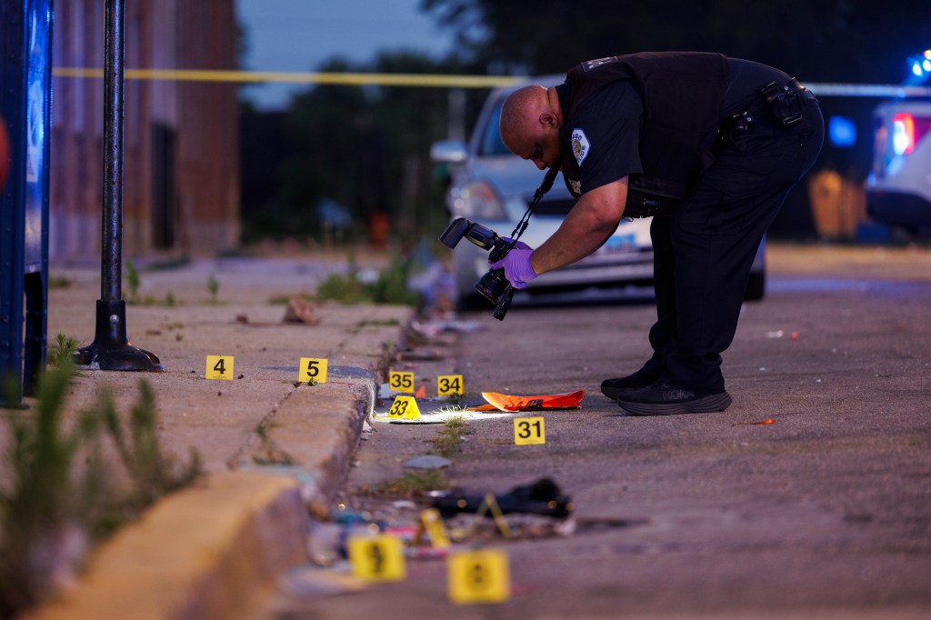 A police officer works at the scene where a 47-year-old man and a 39-year-old man were shot on the 2400 block of West Monroe Street on July 7, 2024, in Chicago. 