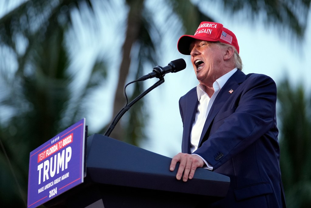 Former President Donald Trump speaking into a microphone at a campaign rally in Trump National Doral Miami, 2024