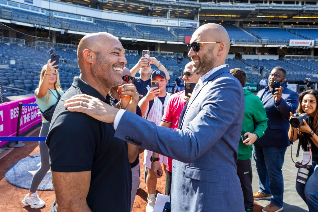 Retired Yankees Mariano Rivera, left, and Derek Jeter greet on the field before a game against the Los Angeles Dodgers at Yankee Stadium Saturday, June 8, 2024.