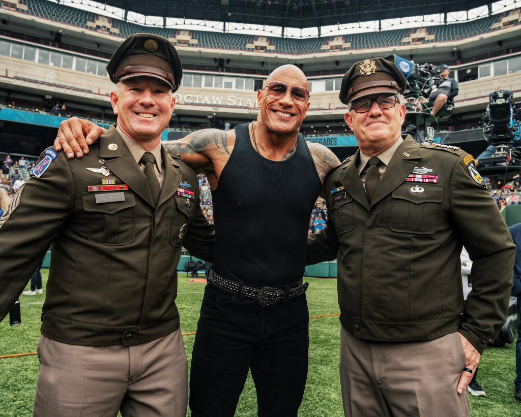 The Rock posing with soldiers. 