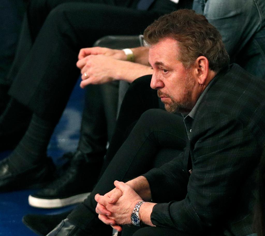 James Dolan looks dejected while sitting courtside at a Knicks game.