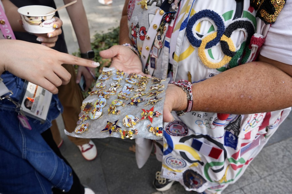 Vivianne Robinson shows off her pin collection to another fan.