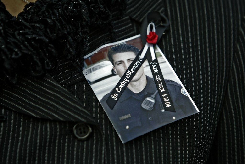 Mourner wearing a photograph of Officer Isaac Espinoza on lapel at his funeral at St. Mary's Cathedral, San Francisco