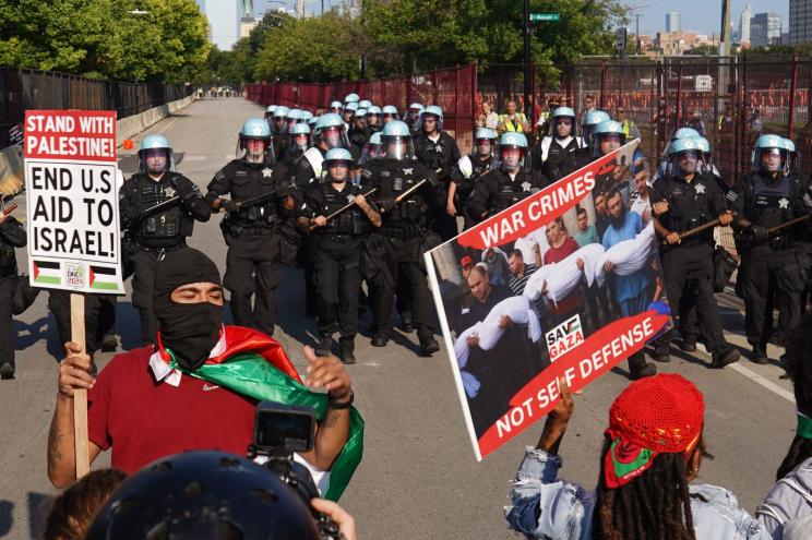 Police in riot gear preparing to hold off protesters near the exterior perimeter at the Democratic National Convention in Chicago, Illinois, 19 August 2024