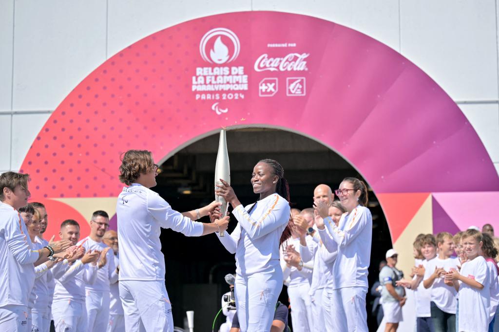 The torch getting passed to the next runner in Coquelles.