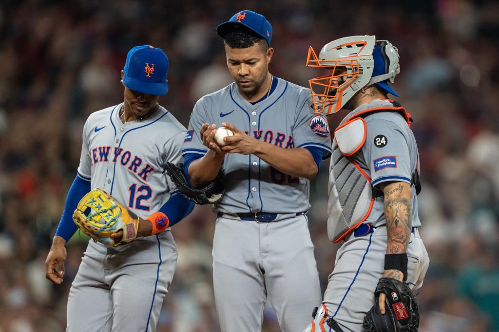 Jose Quintana #62 of the New York Mets meets at the mound with shortstop Francisco Lindor #12 and catcher Francisco Alvarez #4 (R) during the seventh inning of a game against the Seattle Mariners at T-Mobile Park on August 9, 2024