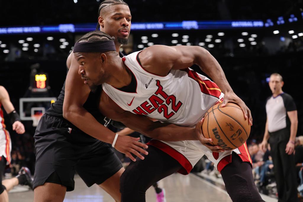 Jimmy Butler of the Miami Heat driving to the basket while Dennis Smith Jr. of the Brooklyn Nets defends during a basketball game