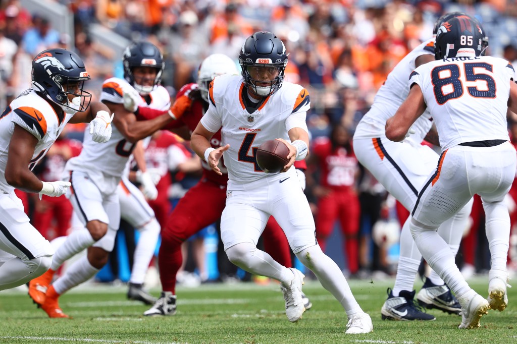 Zach Wilson #4 of the Denver Broncos looks to hand the ball off against the Arizona Cardinals in the second quarter of a preseason game at Empower Field At Mile High on August 25, 2024 in Denver, Colorado. 