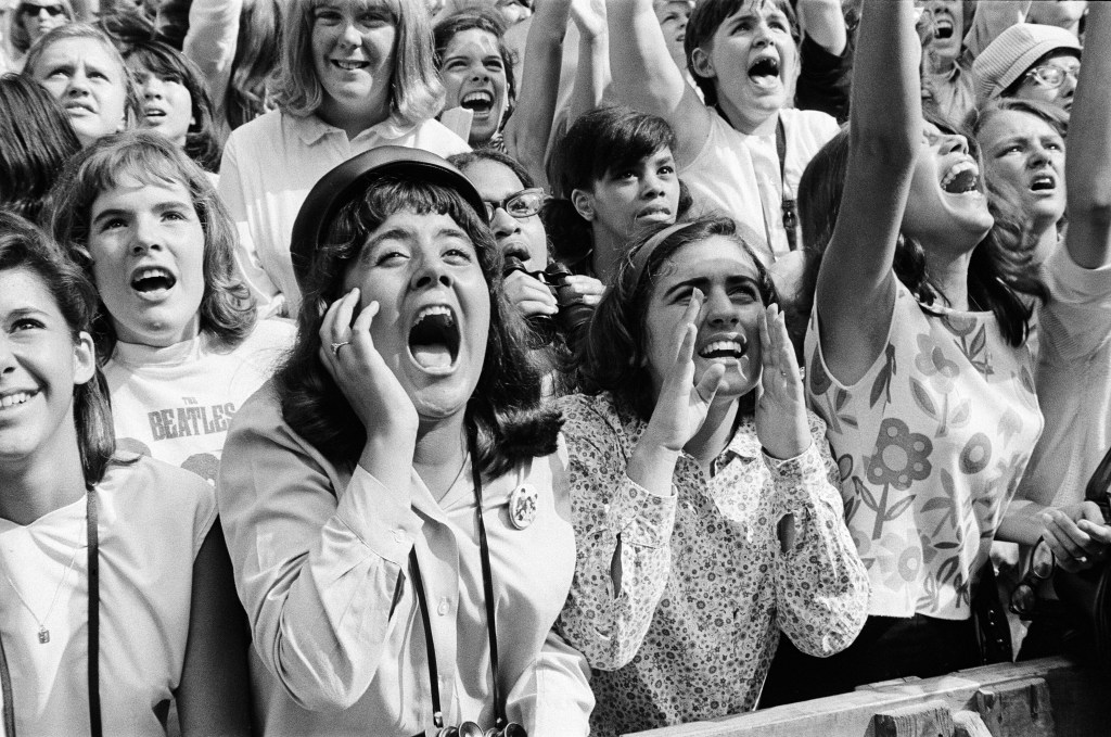 A photo of screaming Beatles fans outside a NYC hotel in 1964