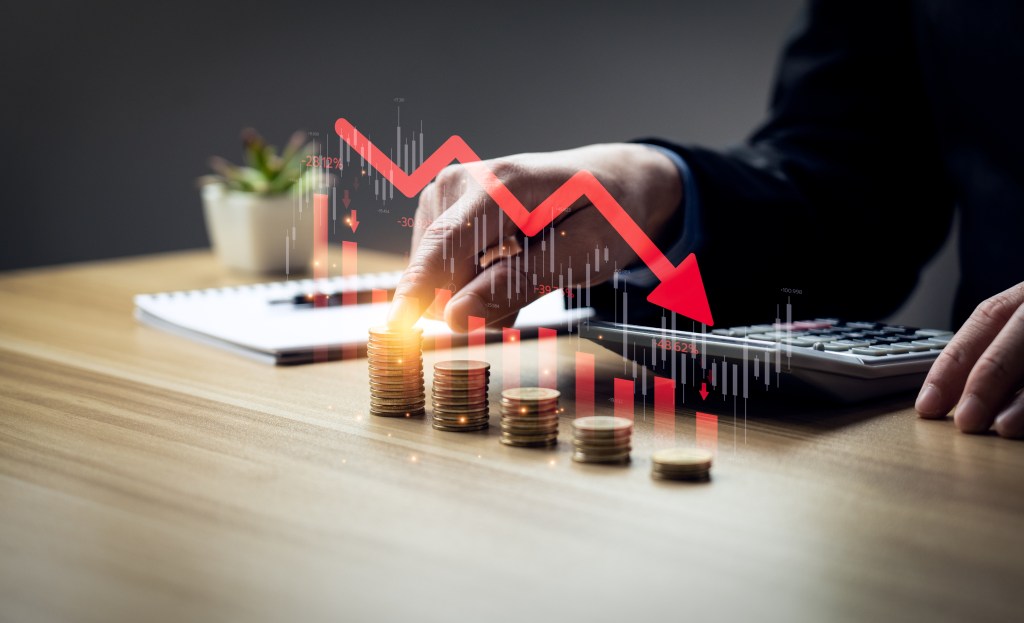 Businessman with falling financial graph chart due to global recession.