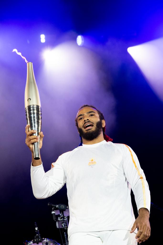 French Paralympic athlete Helios Latchoumanaya with the torch at Rock en Seine music festival, in Saint-Cloud on Aug. 25, 2024.