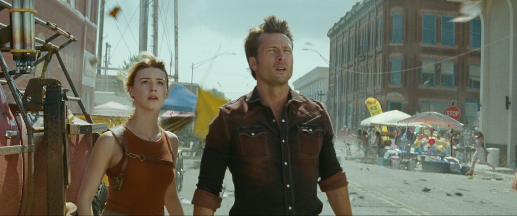 Glen Powell, right, and Daisy Edgar-Jones, left, look ahead in a scene from "Twisters."