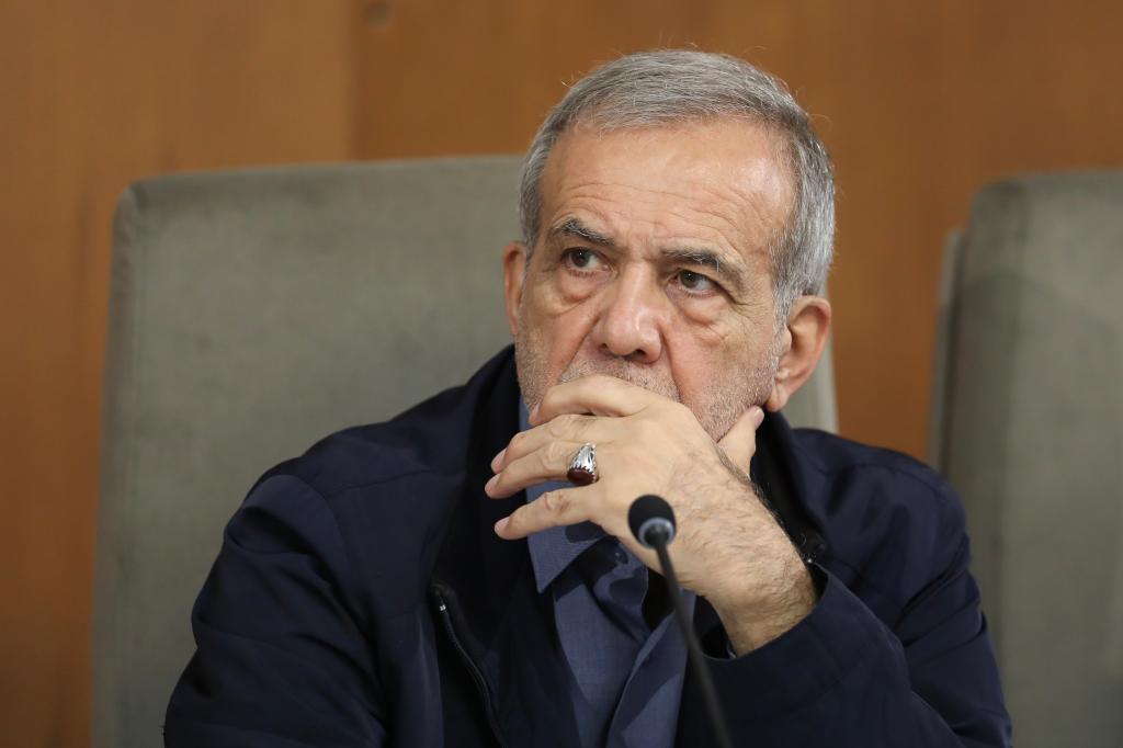 Iranian President Masoud Pezeshkian, a gray-haired man wearing a blue sweater, attends a government meeting in Tehran