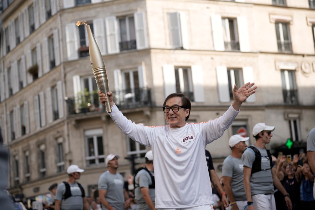 Actor Jackie Chan carrying the Paralympic torch in Paris on Aug. 28, 2024.