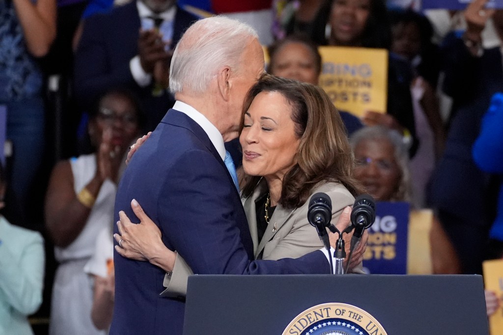 President Joe Biden and Vice President Kamala Harris embracing at a podium during an event at Prince George's Community College