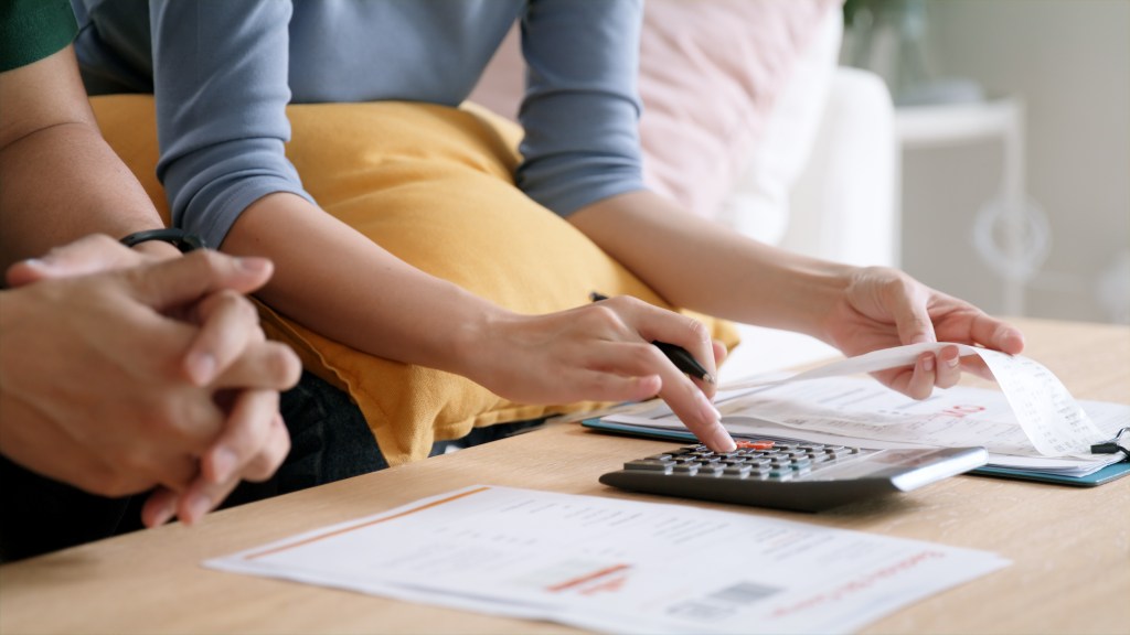  couple paying bills with calculator and paper