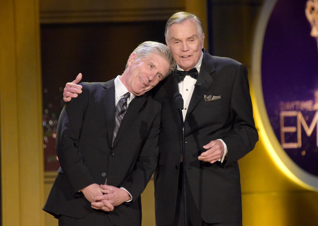 Tom Bergeron, left, rests his head on Peter Marshall's shoulder as they present an award at the 45th annual Daytime Emmy Awards  in Pasadena, Calif.