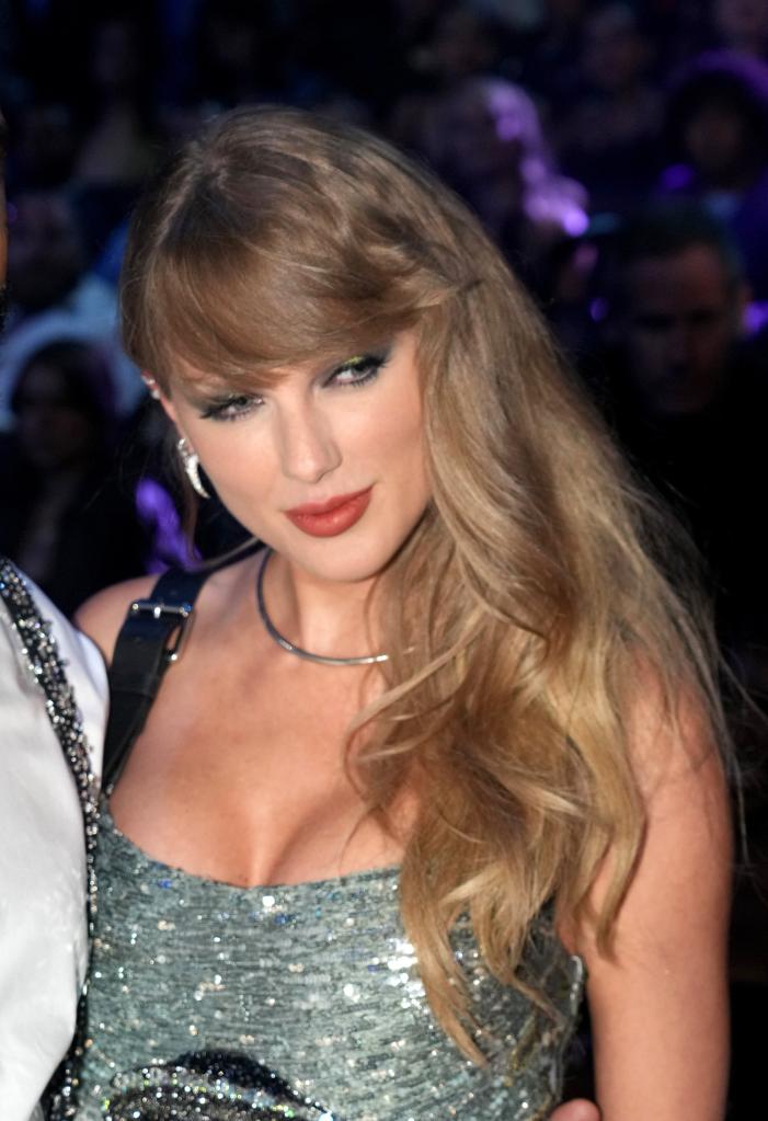 Taylor Swift with long blonde hair, wearing a silver dress, attending the 2024 MTV Video Music Awards in Elmont, New York