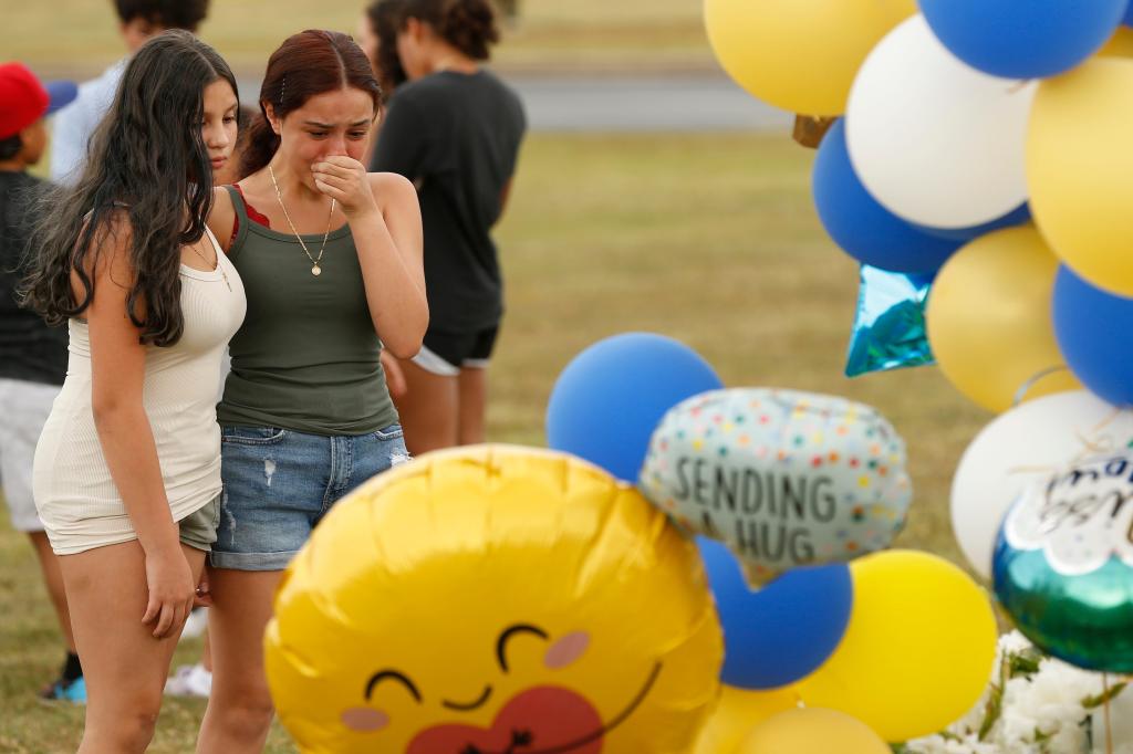 Mourners cry at the Apalachee High School flagpole one day after a shooting occurred at the school in Winder, Ga., on Thursday, Sept. 5, 2024.