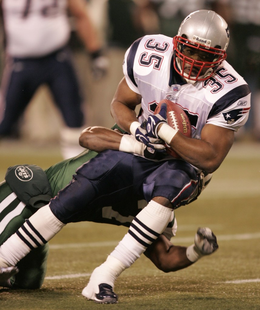 New England Patriots fullback Patrick Pass is brought down by New York Jets linebacker Darrell McClover after picking up a first down during the second quarter Sunday, Dec. 26, 2004, in East Rutherford, New Jersey.