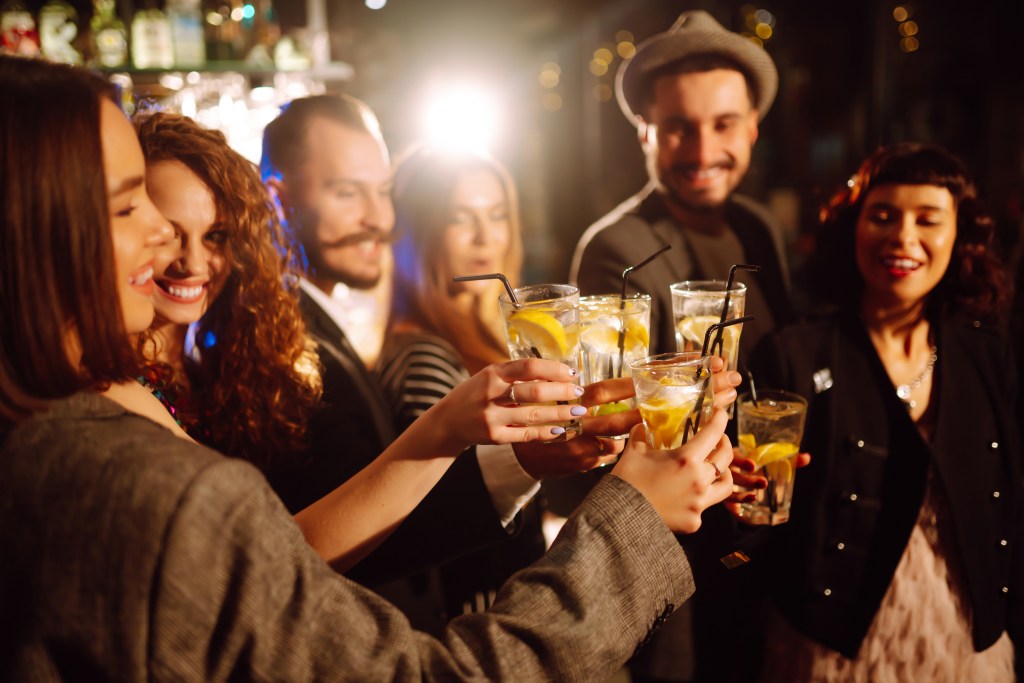 Group of people giving a toast at a bar