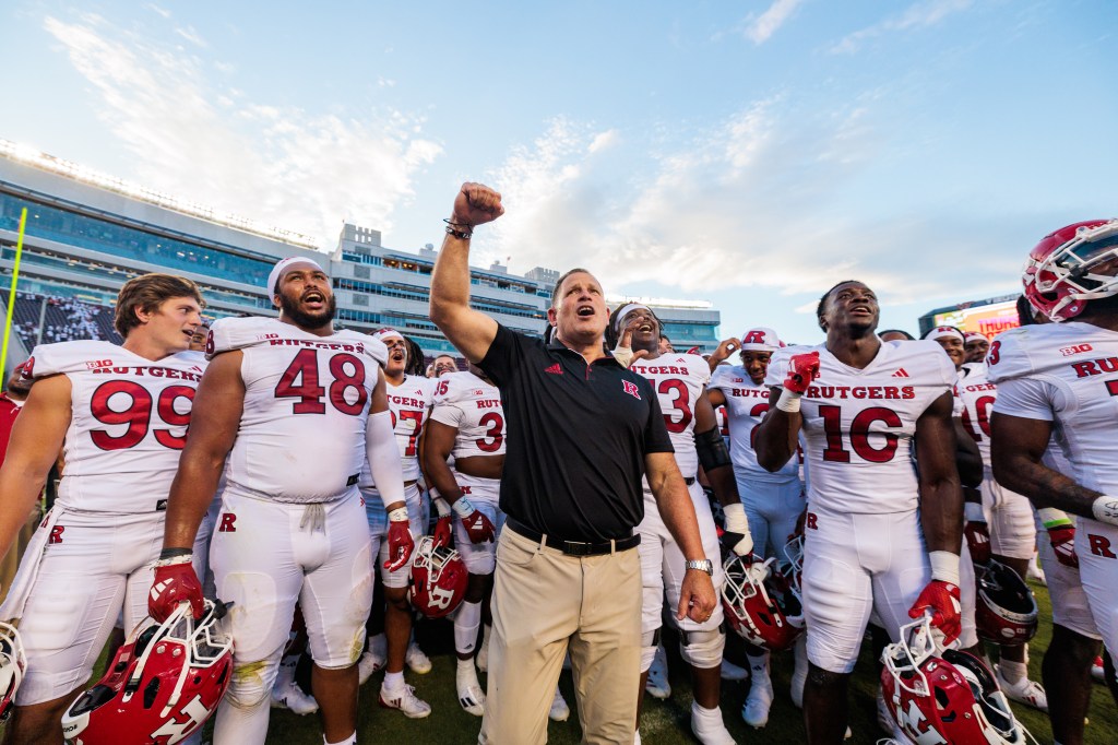 Coach Greg Schiano celebrates with his players after Rutgers' 26-23 win over Virginia Tech on Sept. 21, 2024.