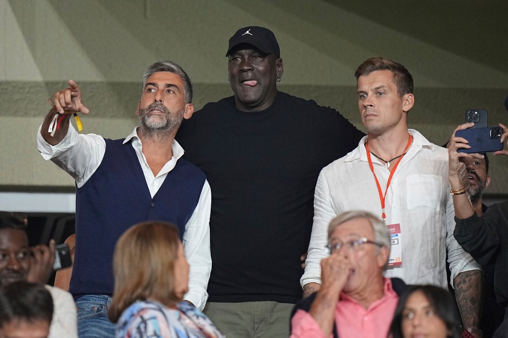 American former professional basketball player Michael Jordan, center, gestures as he attends the Champions League opening phase soccer match between Monaco and Barcelona at the Louis II stadium, in Monaco, Monaco, Thursday, Sept. 19, 2024.