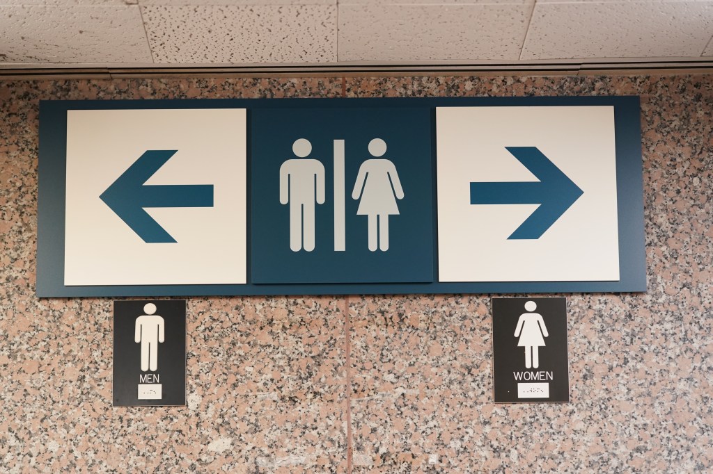 A general view of a men's bathroom and women's bathroom sign .