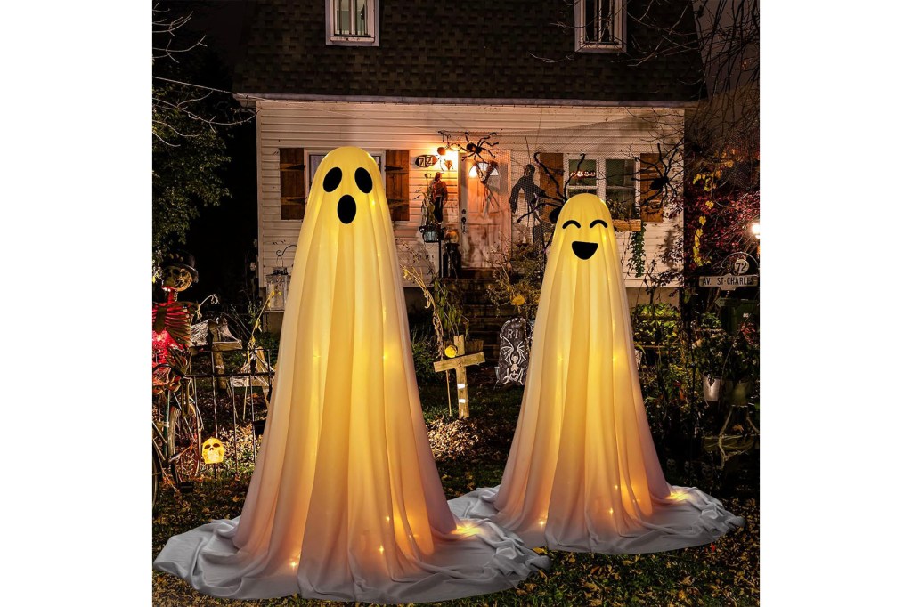 Two white ghosts with lights in front of a house