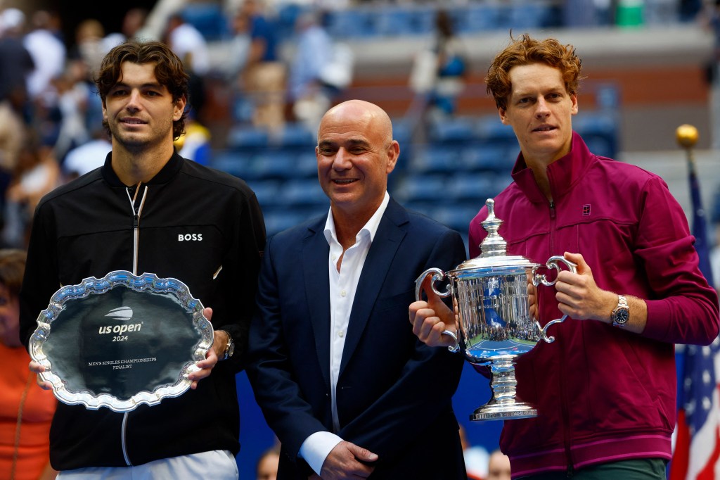 Jannik Sinner (ITA) and Taylor Fritz (USA) pose for a photo alongside tennis legend Andre Agassi after the menâs singles final of the 2024 U.S. Open tennis tournament at USTA Billie Jean King National Tennis Center. 