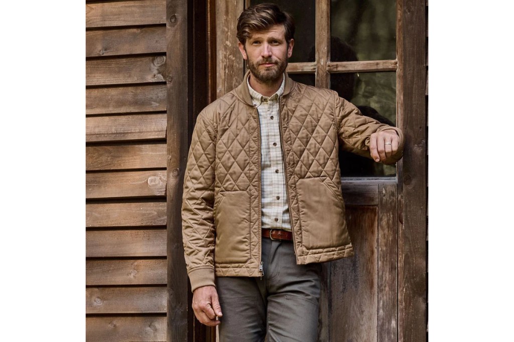 A man standing in front of a wooden door