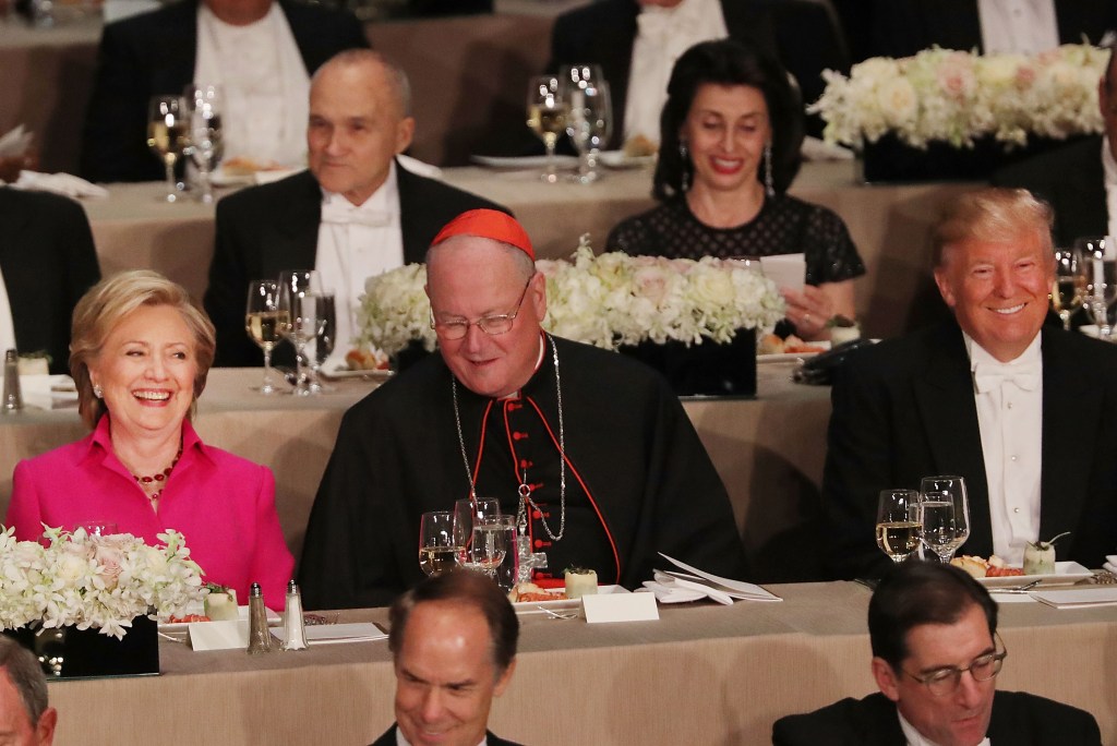 Sitting between Cardinal Timothy Dolan, Hillary Clinton and Donald Trump attend the annual Alfred E. Smith Memorial Foundation Dinner at the Waldorf Astoria on October 20, 2016 in New York City.