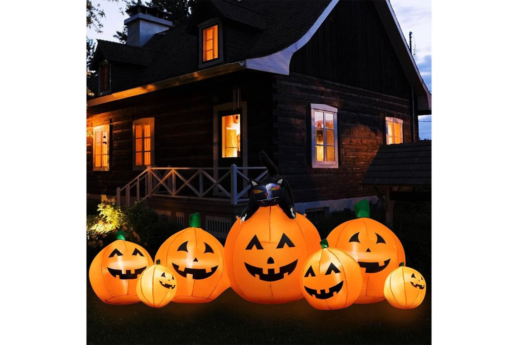 A group of inflatable pumpkins in front of a house