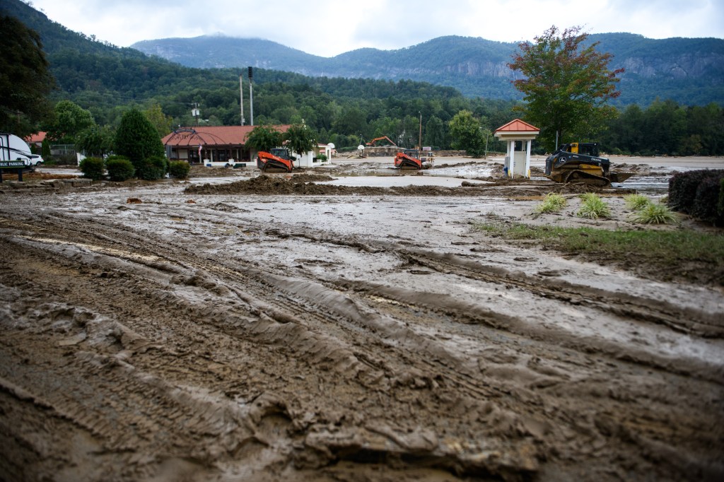 chimney rock north carolina destroyed by storm, filled with mud, with mountains in distance