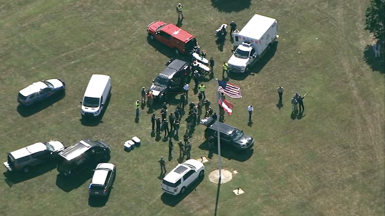 Emergency scene outside Apalachee High School, Winder, Georgia, with group of people around a car after a reported school shooting on Sept. 4, 2024.