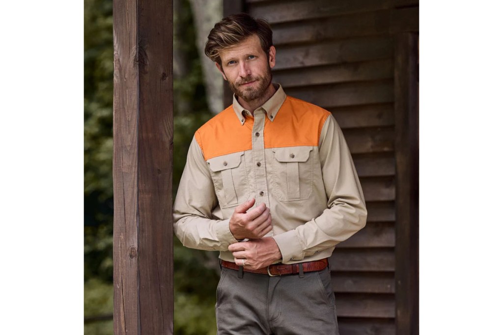 Man standing outside in front of a wooden structure