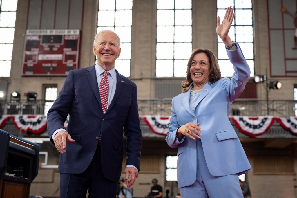 Joe BIden and Kamala Harris waving to a crowd at a campaign event  