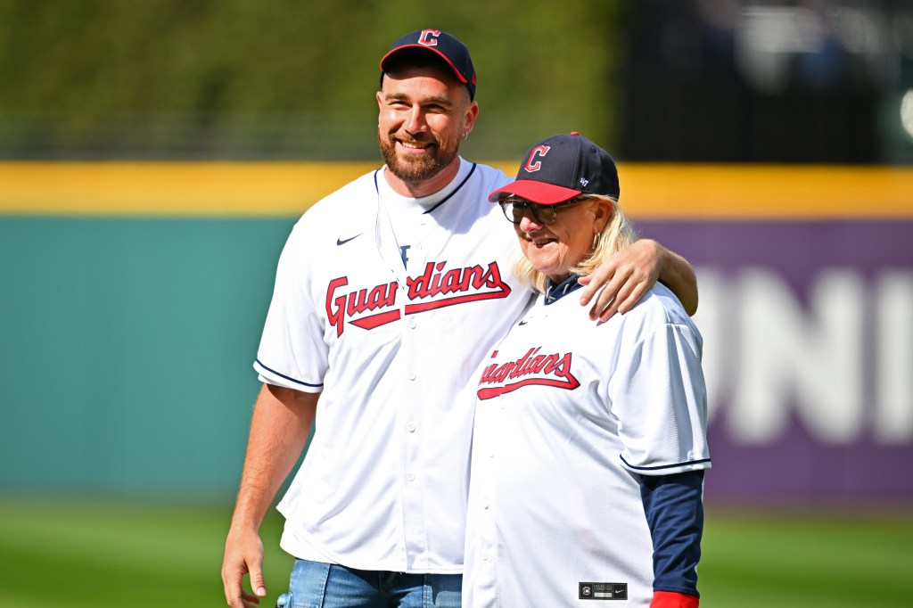 Travis Kelce and his mother Donna standing together on the baseball field, before he throws the first pitch at a Cleveland Guardians vs Seattle Mariners game