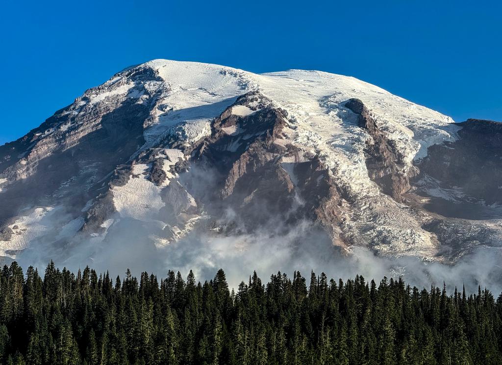 Melting ice at the peak of Mount Rainier is responsible for its drop in height.