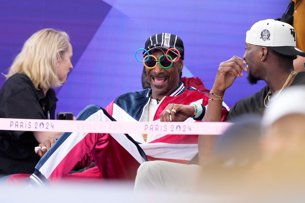 American artist Snoop Dogg, center, sits in the audience prior to the breaking competition at La Concorde Urban Park at the 2024 Summer Olympics, Friday, Aug. 9, 2024, in Paris, France.