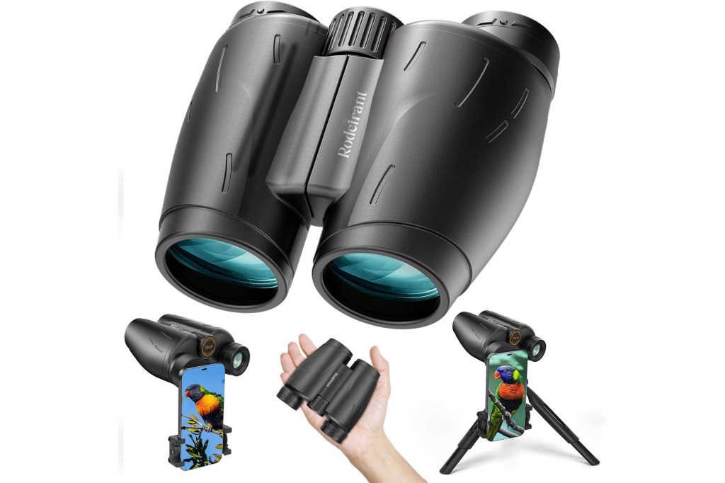 A group of binoculars accompanied by a phone and a hand