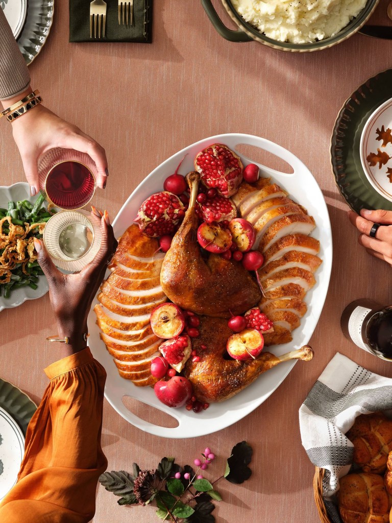 A plate of traditional Thanksgiving meal offered by Target for $5 per person, with an individual holding glasses of wine