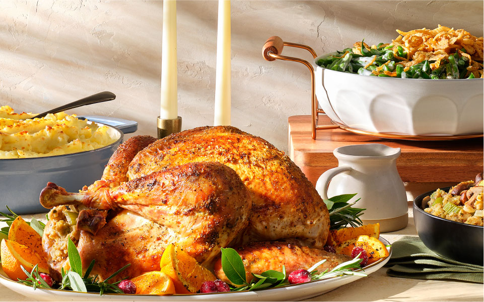 A turkey on a platter with a bowl of salad, part of Target's affordable Thanksgiving meal offer.