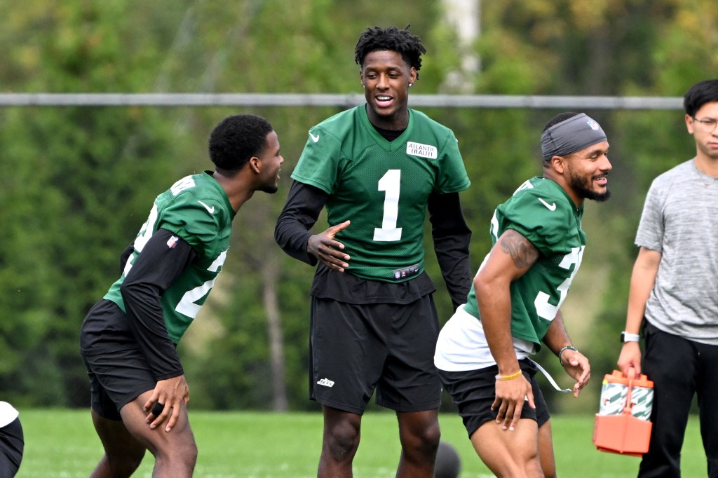 Jets cornerback Sauce Gardner (1), cornerback Jarrick Bernard-Converse (29) and cornerback Michael Carter II (30) have fun during stretching before practice