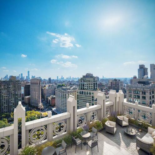 A rooftop patio with chairs and tables overlooking a city skyline at 11 E 26th St, designed as a modern workplace to attract top tenants